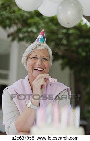 Older woman laughing at birthday party View Large Photo Image Stock Photo - Older woman laughing at birthday party. Fotosearch