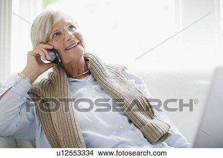 Picture - Older woman talking on cell phone. Fotosearch