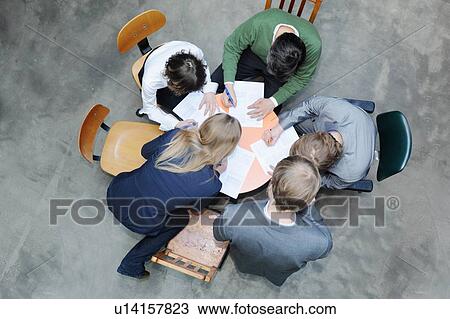 Overhead view of business people at desk View Large Photo Image Stock Image - Overhead view of business people at desk. Fotosearch