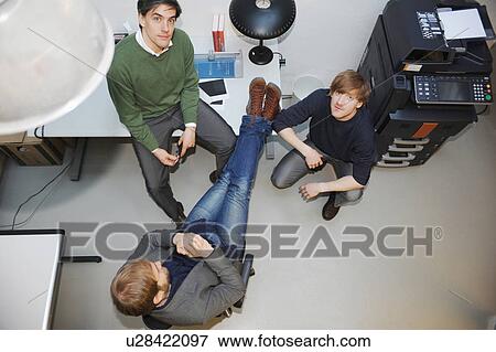 Stock Photo - Overhead view of businessmen in office. Fotosearch