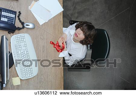 Stock Image - Overhead view of businesswoman at desk. Fotosearch