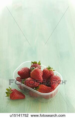 Stock Image - Plastic container of strawberries. Fotosearch