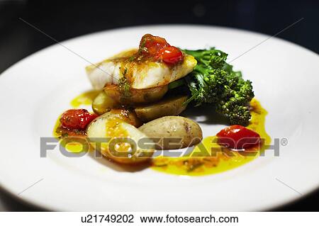 Stock Image - Plate of scallops, potatoes, vegetables. Fotosearch