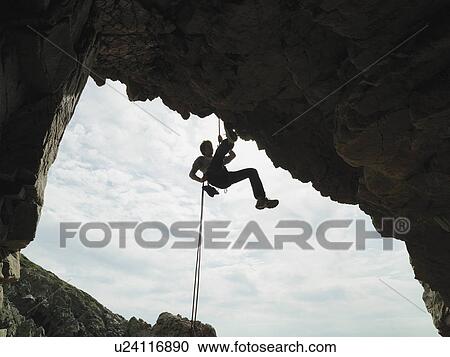 Rock climber rappelling down rock face View Large Photo Image Stock Image - Rock climber rappelling down rock face. Fotosearch