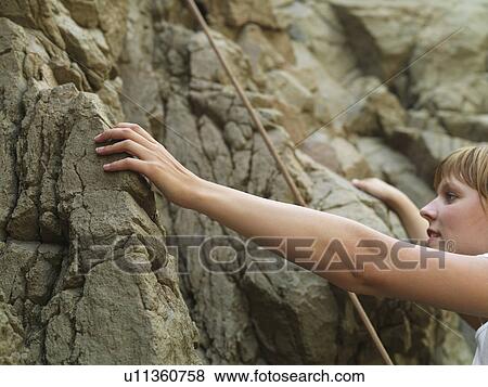 Stock Photo - Rock climber scaling steep rock face. Fotosearch