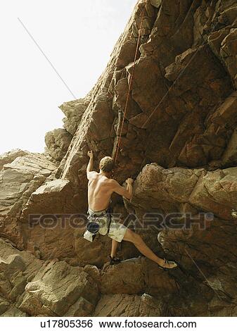 Rock climber scaling steep rock face View Large Photo Image Stock Photograph - Rock climber scaling steep rock face. Fotosearch