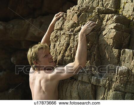 Stock Photograph - Rock climber scaling steep rock face. Fotosearch