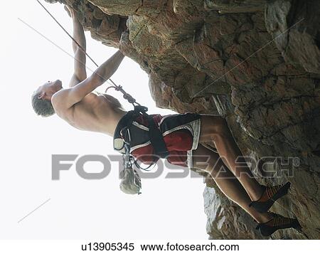 Stock Photography - Rock climber scaling steep rock face. Fotosearch