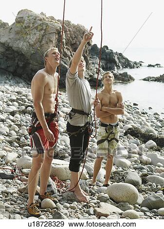 Stock Photo - Rock climbers examining rock face. Fotosearch