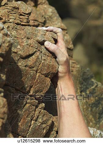 Stock Photo - Rock climbers hand on steep rock face. Fotosearch