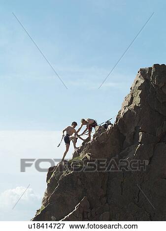 Rock climbers scaling steep rock face View Large Photo Image Stock Photo - Rock climbers scaling steep rock face. Fotosearch