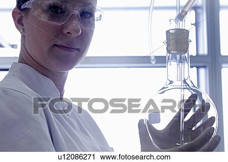 Scientist holding beaker in lab View Large Photo Image Stock Image - Scientist holding beaker in lab. Fotosearch