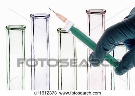 Stock Image - Scientist holding syringe in lab. Fotosearch