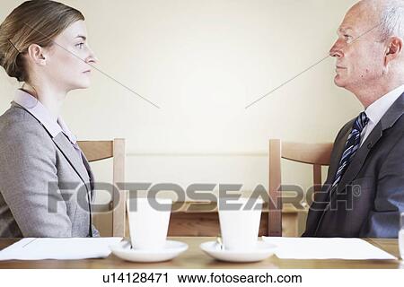 Serious business people sitting in cafe View Large Photo Image Stock Image - Serious business people sitting in cafe. Fotosearch