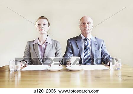 Serious business people sitting in cafe View Large Photo Image Stock Photograph - Serious business people sitting in cafe. Fotosearch