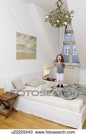 Shouting girl jumping on bed View Large Photo Image Stock Image - Shouting girl jumping on bed. Fotosearch