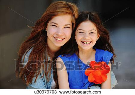 Sisters smiling together outdoors View Large Photo Image Stock Image - Sisters smiling together outdoors. Fotosearch