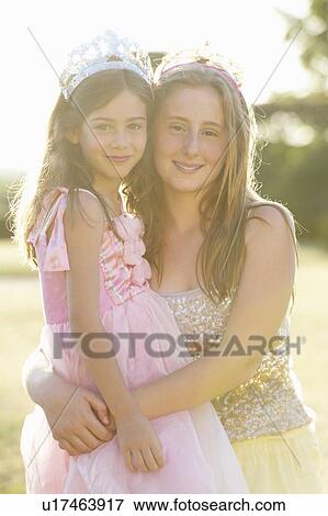 Stock Photo - Sisters smiling together outdoors. Fotosearch