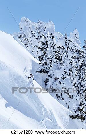Skier coasting down snowy slope View Large Photo Image Stock Image - Skier coasting down snowy slope. Fotosearch