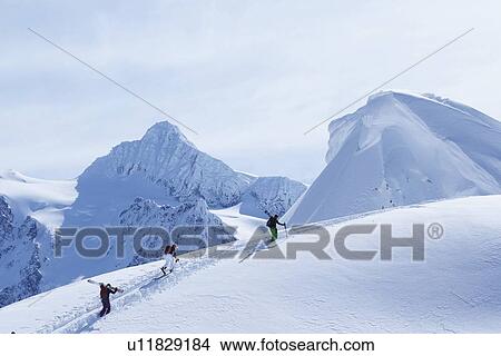 Skiers climbing snowy slope View Large Photo Image Picture - Skiers climbing snowy slope. Fotosearch