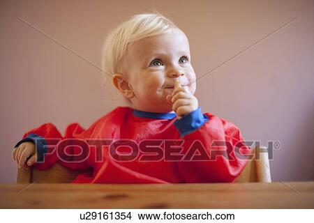 Smiling baby girl sitting at table View Large Photo Image Picture - Smiling baby girl sitting at table. Fotosearch