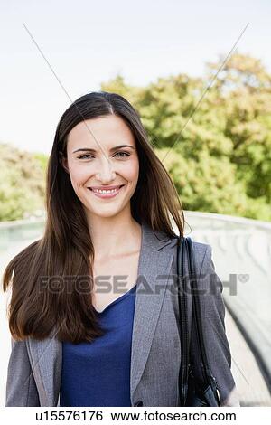 Smiling businesswoman walking outdoors View Large Photo Image Stock Photograph - Smiling businesswoman walking outdoors. Fotosearch