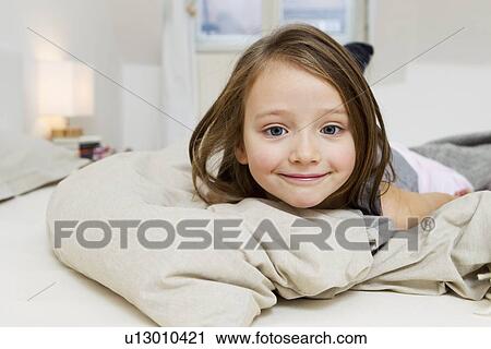 Smiling girl laying on bed View Large Photo Image Stock Image - Smiling girl laying on bed. Fotosearch