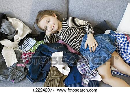 Smiling girl laying on pile of laundry View Large Photo Image Stock Photo - Smiling girl laying on pile of laundry. Fotosearch