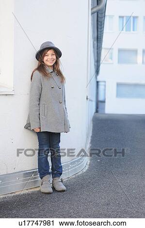 Smiling girl leaning on wall outdoors View Large Photo Image Stock Image - Smiling girl leaning on wall outdoors. Fotosearch