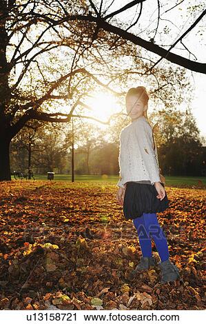 Smiling girl playing in autumn leaves View Large Photo Image Stock Image - Smiling girl playing in autumn leaves. Fotosearch