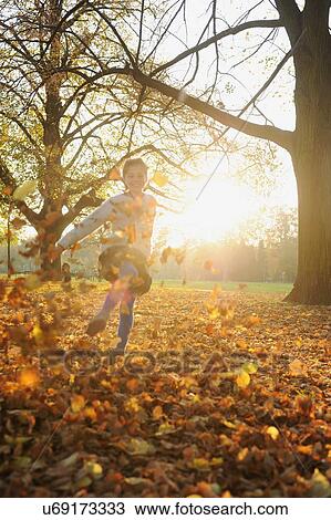 Smiling girl playing in autumn leaves View Large Photo Image Stock Image - Smiling girl playing in autumn leaves. Fotosearch