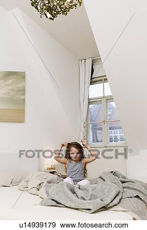 Smiling girl playing in bed View Large Photo Image Stock Photo - Smiling girl playing in bed. Fotosearch