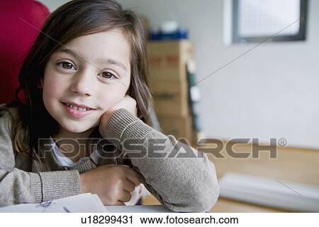 Smiling girl sitting at desk View Large Photo Image Stock Image - Smiling girl sitting at desk. Fotosearch