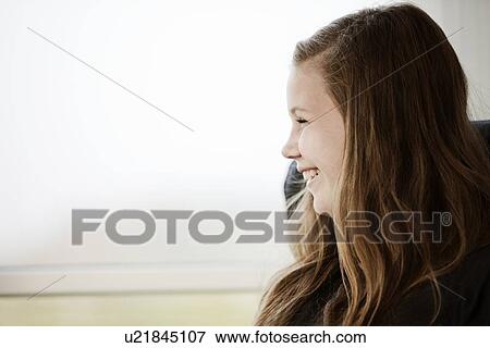 Smiling girl sitting indoors View Large Photo Image Stock Photo - Smiling girl sitting indoors. Fotosearch