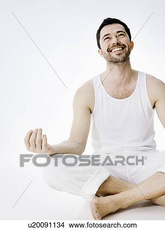 Smiling man sitting in meditative pose View Large Photo Image Picture - Smiling man sitting in meditative pose. Fotosearch