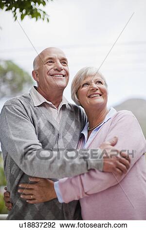 Smiling older couple hugging outdoors View Large Photo Image Stock Image - Smiling older couple hugging outdoors. Fotosearch