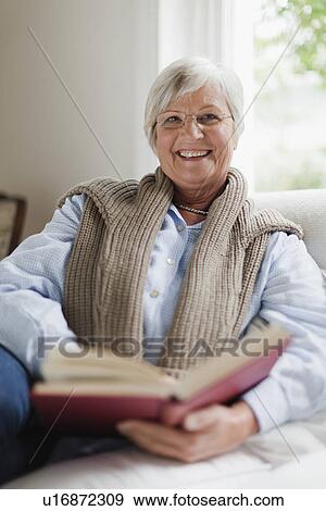 Smiling older woman reading book View Large Photo Image Stock Photo - Smiling older woman reading book. Fotosearch