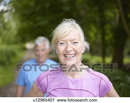 Stock Photo - Smiling older woman standing outside. Fotosearch