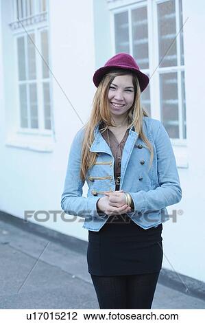 Stock Image - Smiling teenage girl standing outdoors. Fotosearch