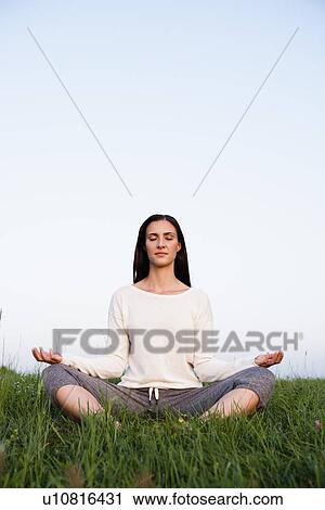 Smiling woman meditating in park View Large Photo Image Stock Image - Smiling woman meditating in park. Fotosearch