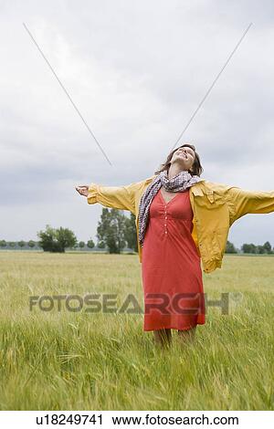 Smiling woman standing in tall grass View Large Photo Image Stock Image - Smiling woman standing in tall grass. Fotosearch