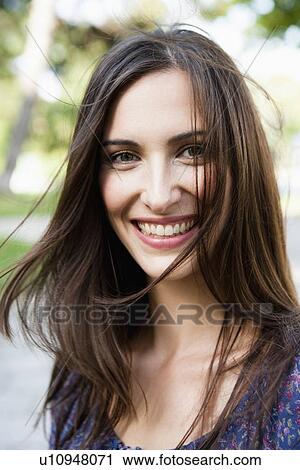 Stock Image - Smiling woman standing outdoors. Fotosearch