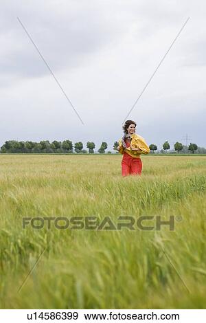 Smiling woman walking in tall grass View Large Photo Image Stock Photo - Smiling woman walking in tall grass. Fotosearch