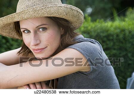 Smiling woman wearing sunhat outdoors View Large Photo Image Stock Photo - Smiling woman wearing sunhat outdoors. Fotosearch
