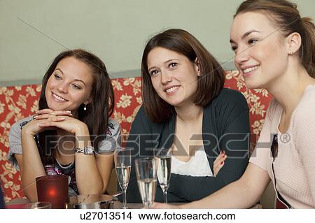 Picture - Smiling women having champagne in cafe. Fotosearch