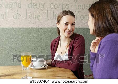 Picture - Smiling women talking in cafe. Fotosearch