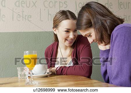 Stock Photo - Smiling women talking in cafe. Fotosearch