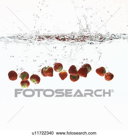 Stock Image - Strawberries splashing in water. Fotosearch
