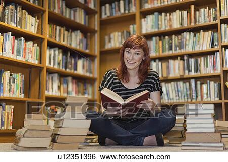 Student in pile of books in library View Large Photo Image Stock Photograph - Student in pile of books in library. Fotosearch