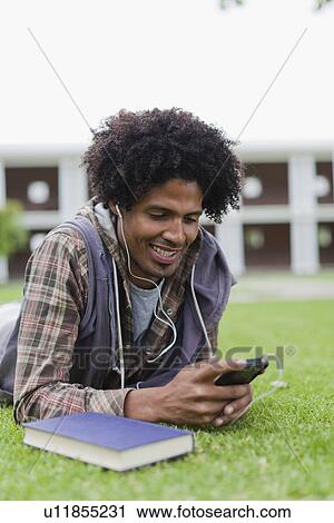 Student listening to mp3 player on grass View Large Photo Image Stock Image - Student listening to mp3 player on grass. Fotosearch